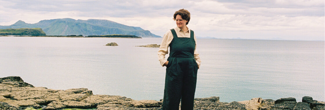 Iona Lane, standing at the edge of a lake